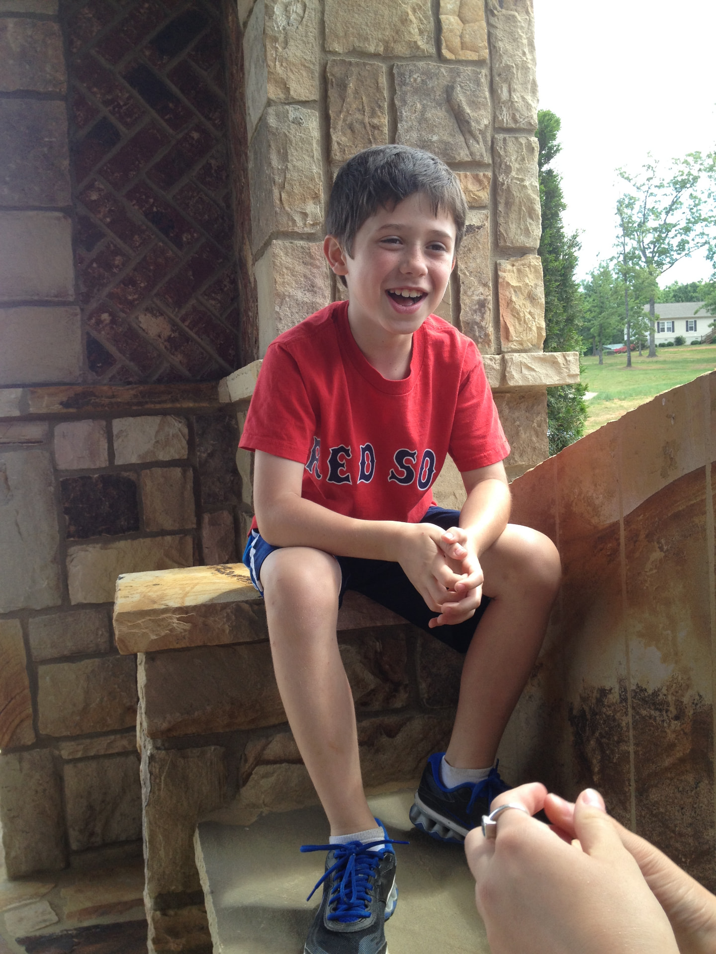 Boy laughing on a stone porch step