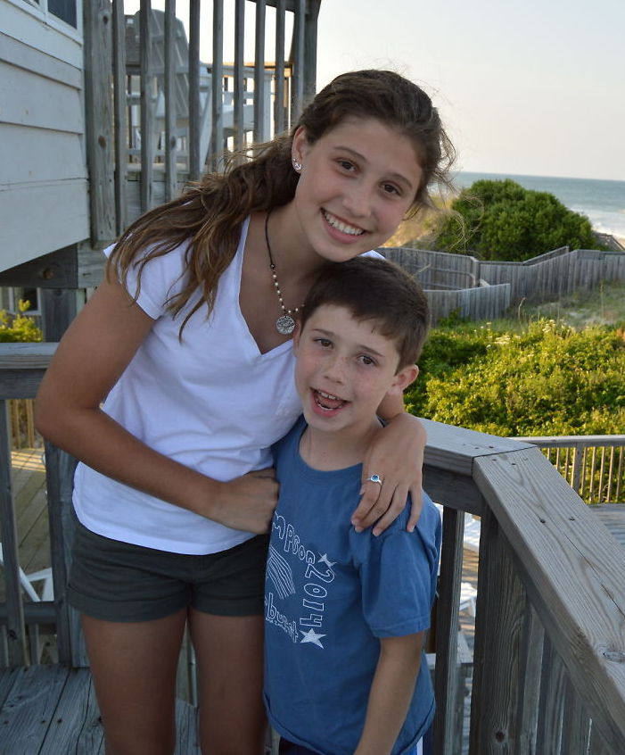 Sister and brother smiling together at the beach